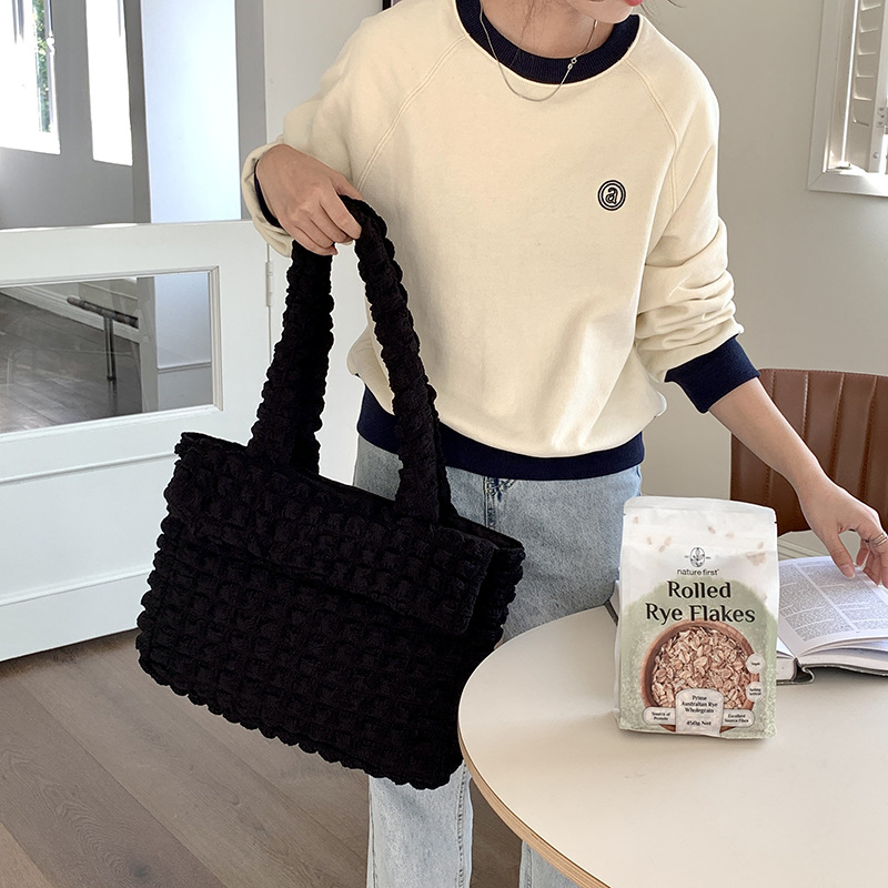 The puffer material gives it a unique texture and the bag is available in a variety of colors to suit your personal style.