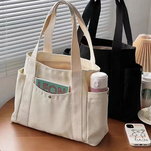 This canvas tote bag with pockets offers extra convenience for organizing small items.