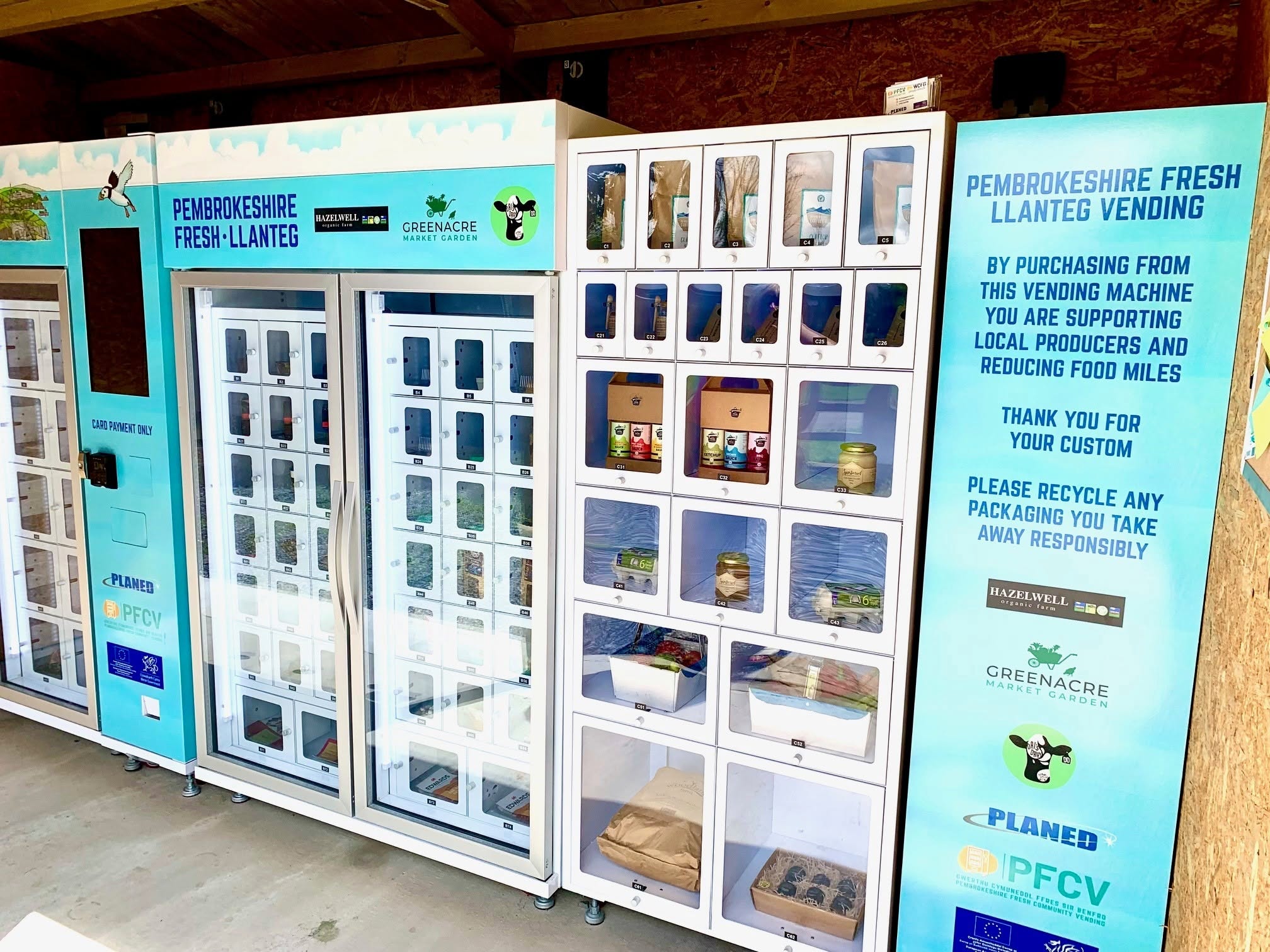 Multi-door locker vending machine displaying fresh agriculture products like eggs, milk, and organic vegetables outside a UK farm stand