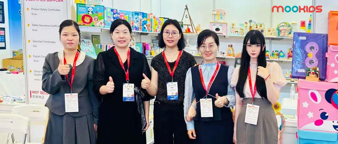 At CTE China Toy Expo, the MOOKIDS team poses in front of their booth (showcasing educational toys and certified products), giving thumbs-up to highlight confidence in quality kids' toys.