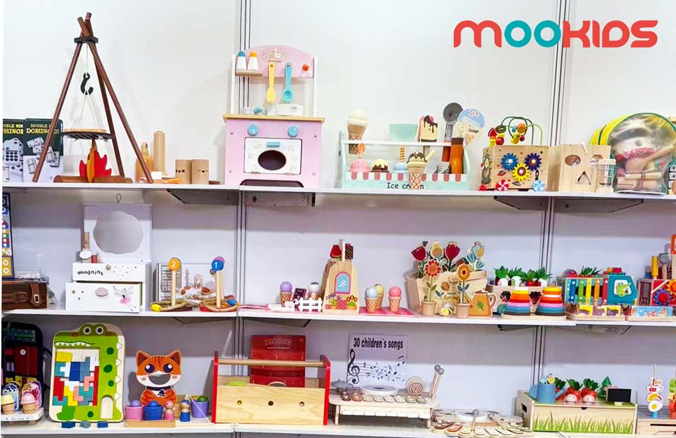 At CTE China Toy Expo, MOOKIDS showcases various wooden educational toys and role-play sets, like a pink pretend kitchen and animal-shaped puzzles, for kids’ fun learning.