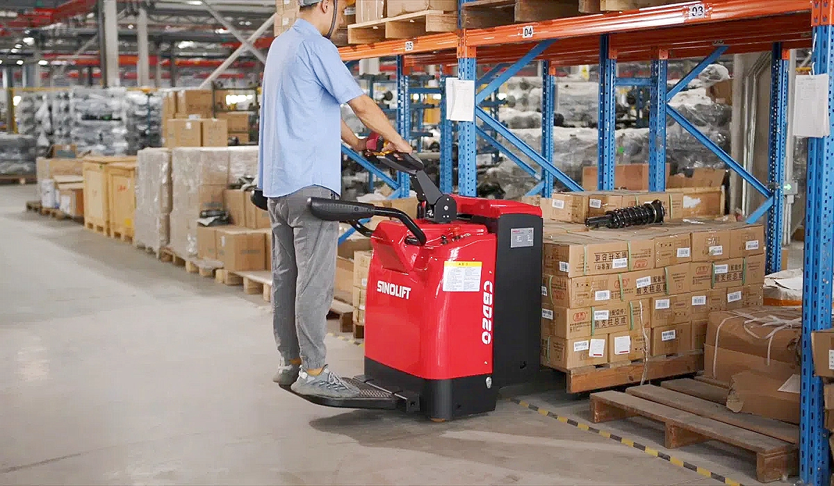 Operator safely using an electric pallet truck with ergonomic controls, preventing strain and injury