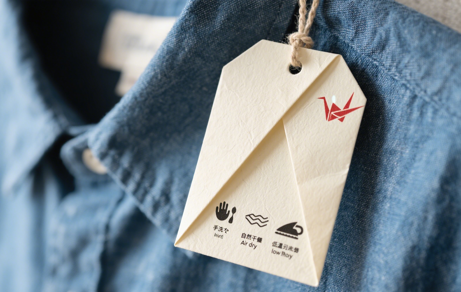 Japanese-inspired origami clothing hang tag with care instructions.