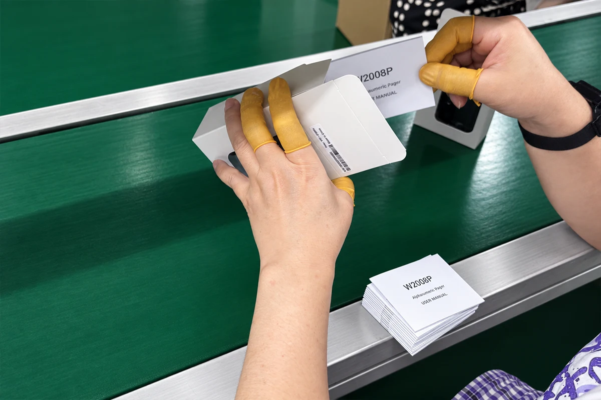 WEX staff placing a W2028 user manual into an individual pager box