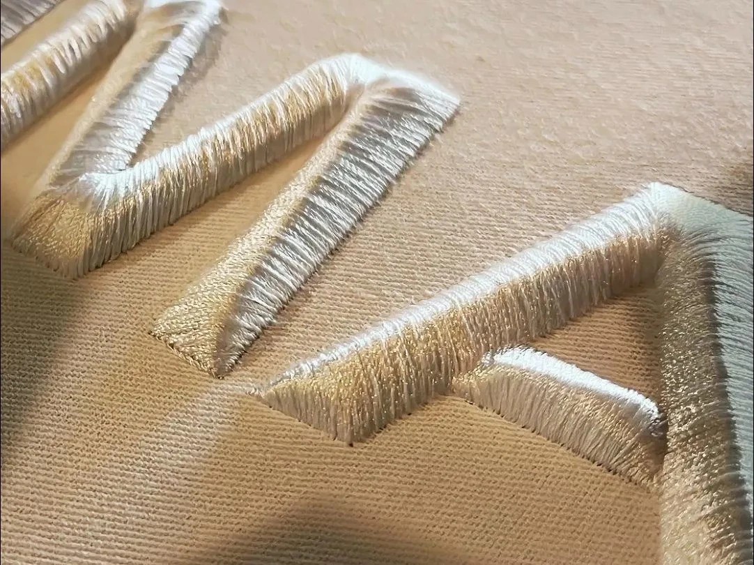 3D puff embroidery with foam-backed raised lettering