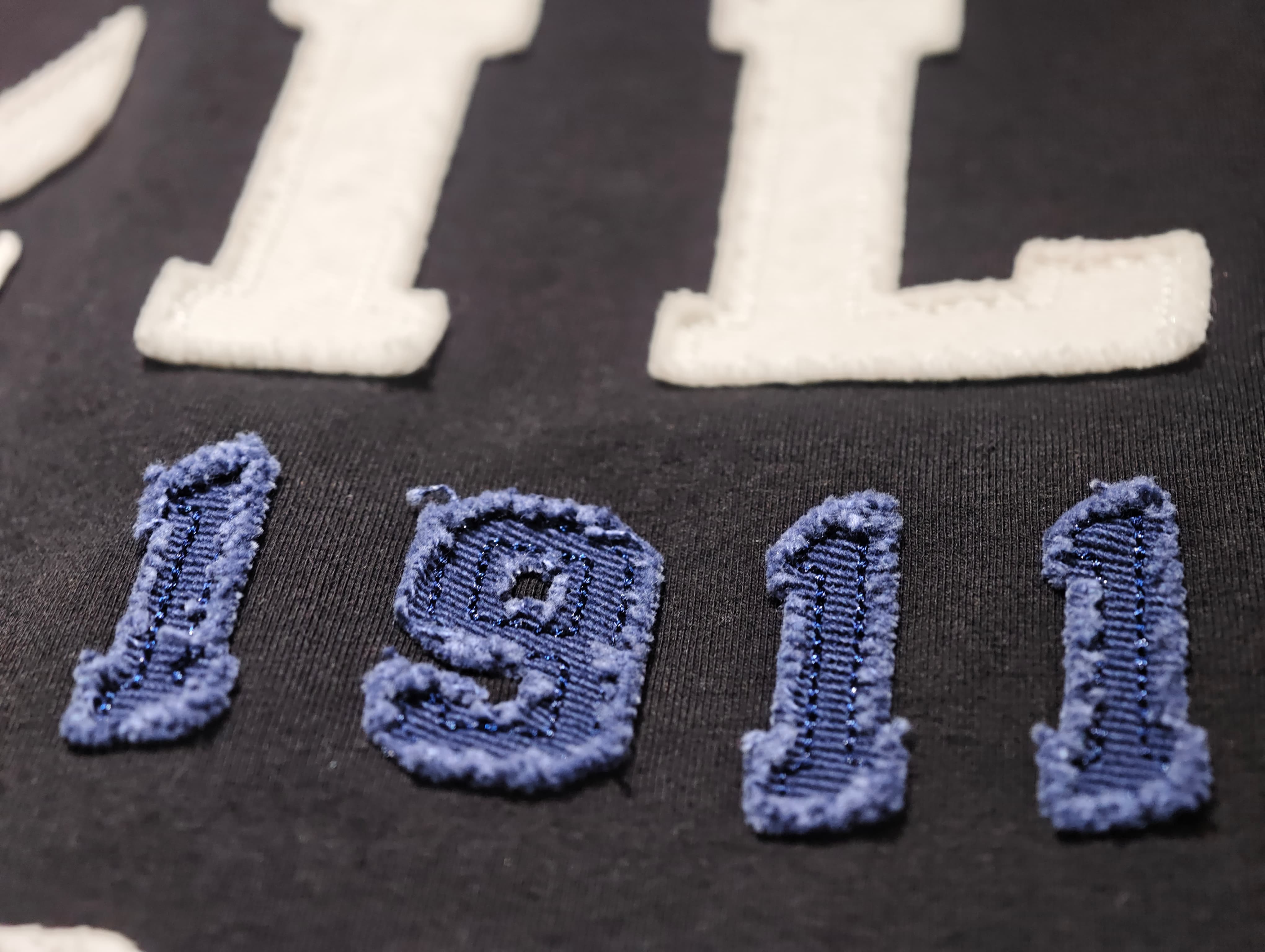 Frayed appliqué embroidery with distressed fabric edges
