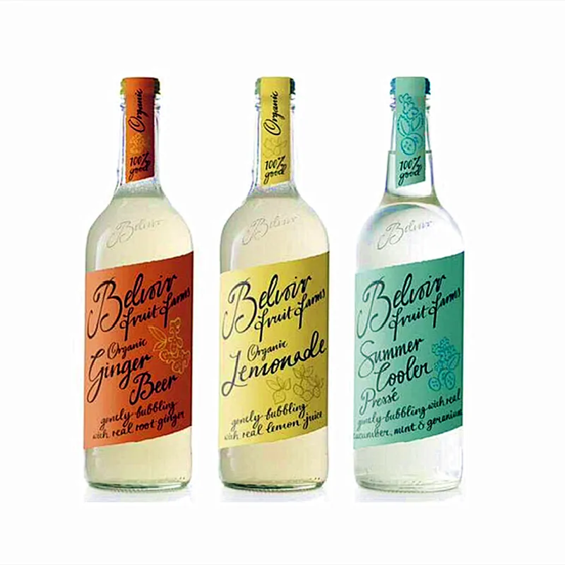 La botella de jugo de vidrio de forma redonda de diferentes tamaños tiene corcho y etiqueta