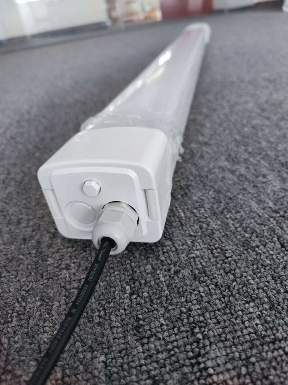 Front view of Lumin all-plastic tri-proof LED batten light with PC housing and frosted diffuser for uniform glare-free illumination in warehouses.