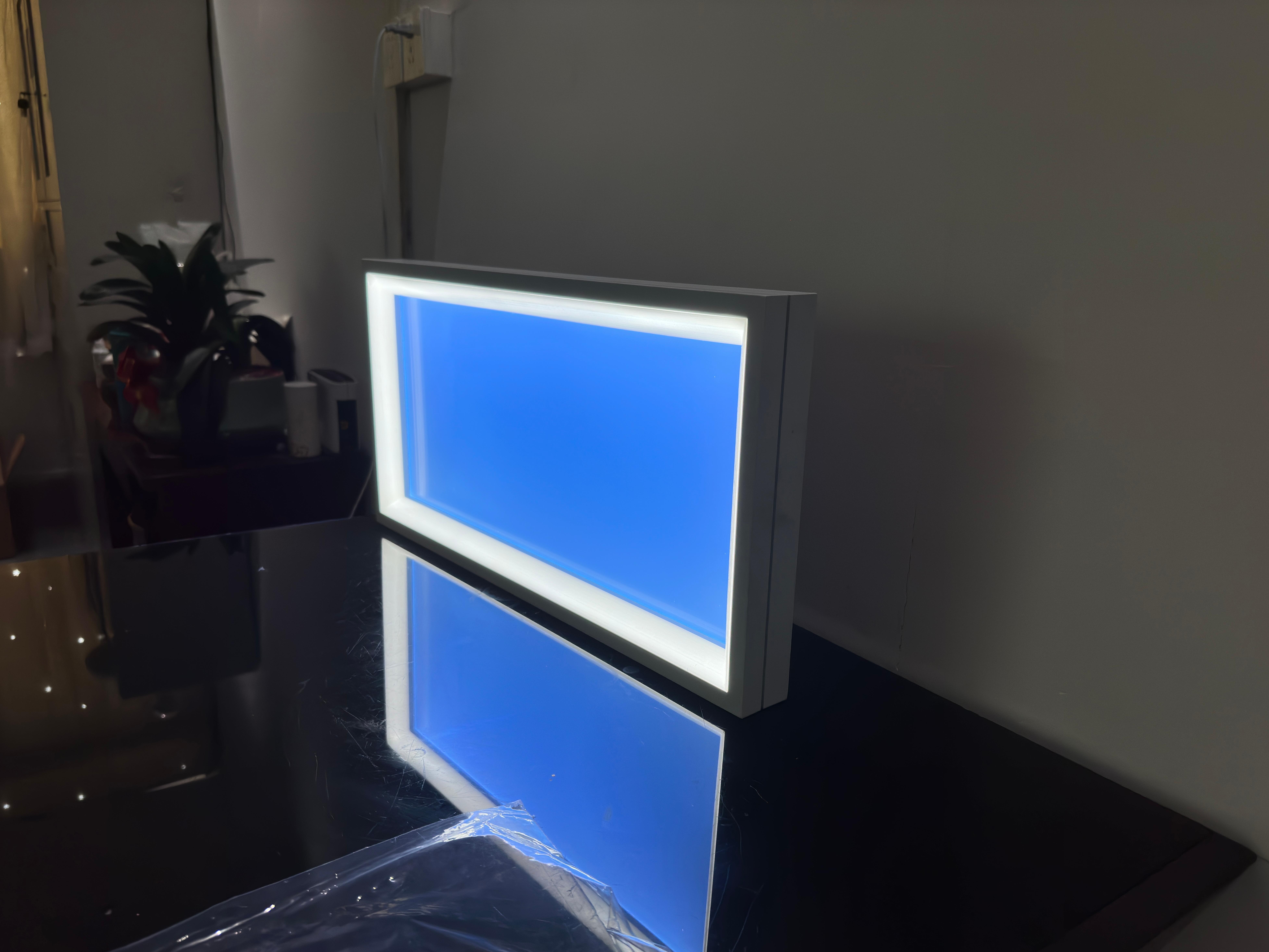 Lumin H50 ultra-thin artificial skylight with 50mm slim profile, featuring tunable white perimeter lighting and central blue sky optical panel, installed in a minimalist office or study room.