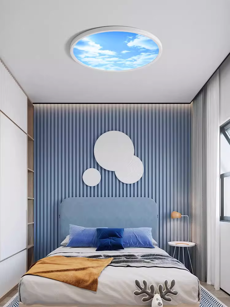 Lumin circular LED skylight panel installed in bedroom ceiling with blue sky white cloud motif