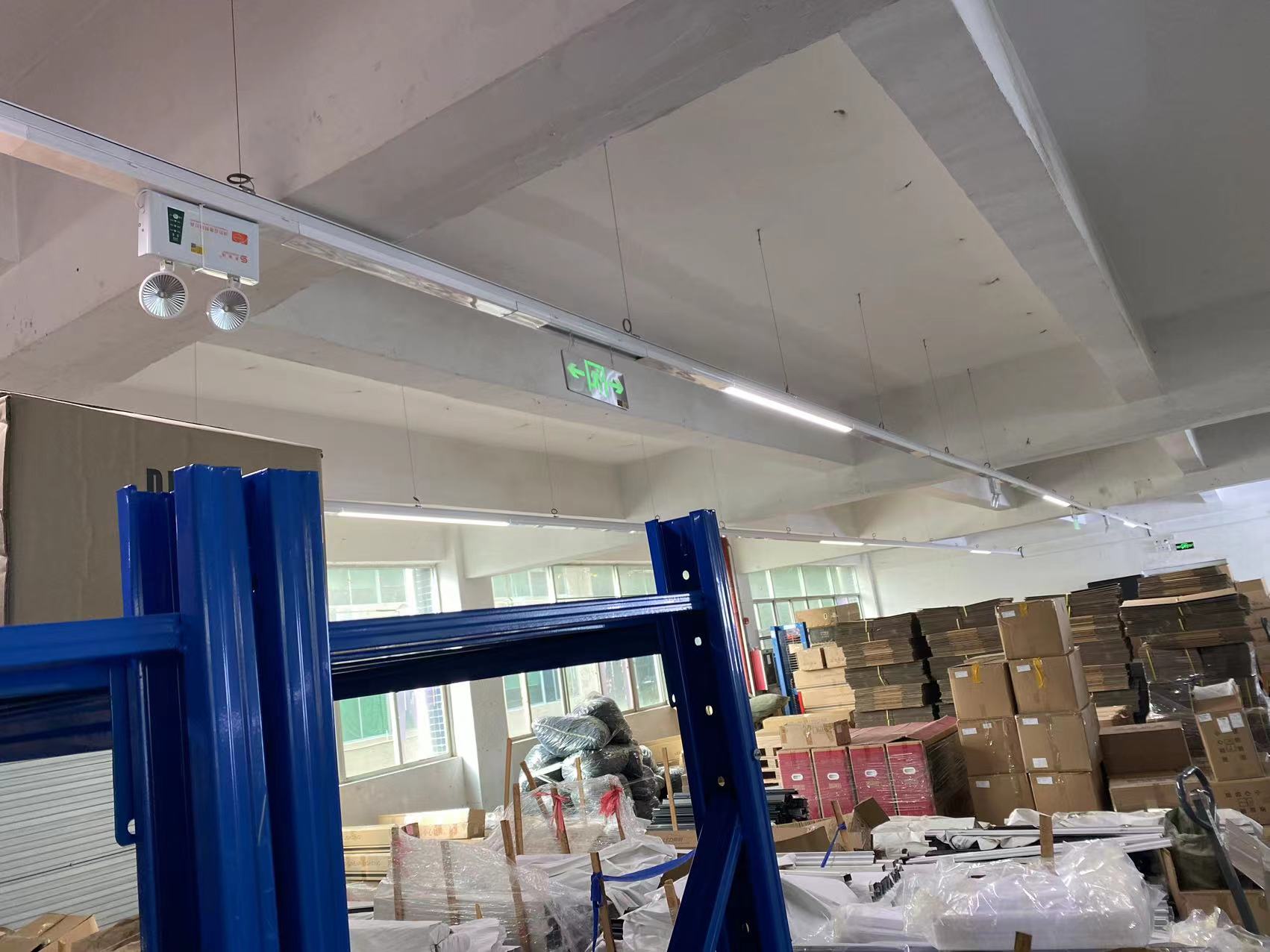 Lumin X1 linear trunking lighting system installed in a high-bay warehouse aisle, providing continuous uniform illumination for rack storage areas.