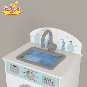 Kinder im neuen Design spielen eine hölzerne Waschmaschine mit Waschbecken W10D458