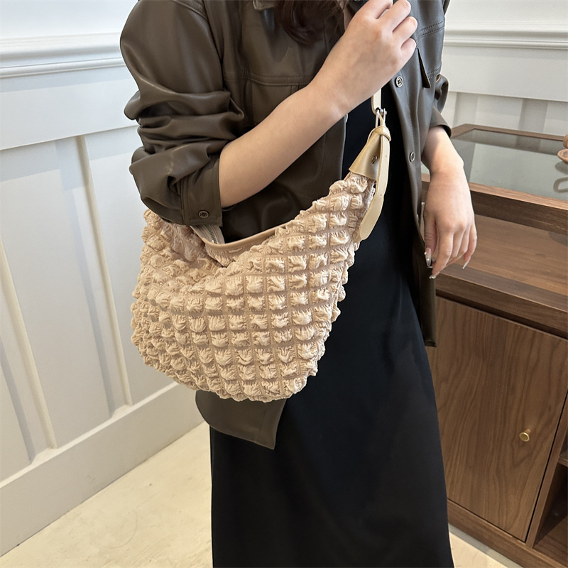 A spacious and elegant quilted puffy tote, designed with a plush quilted exterior and ample storage space. Ideal for travel, work, and everyday essentials, combining style and functionality.