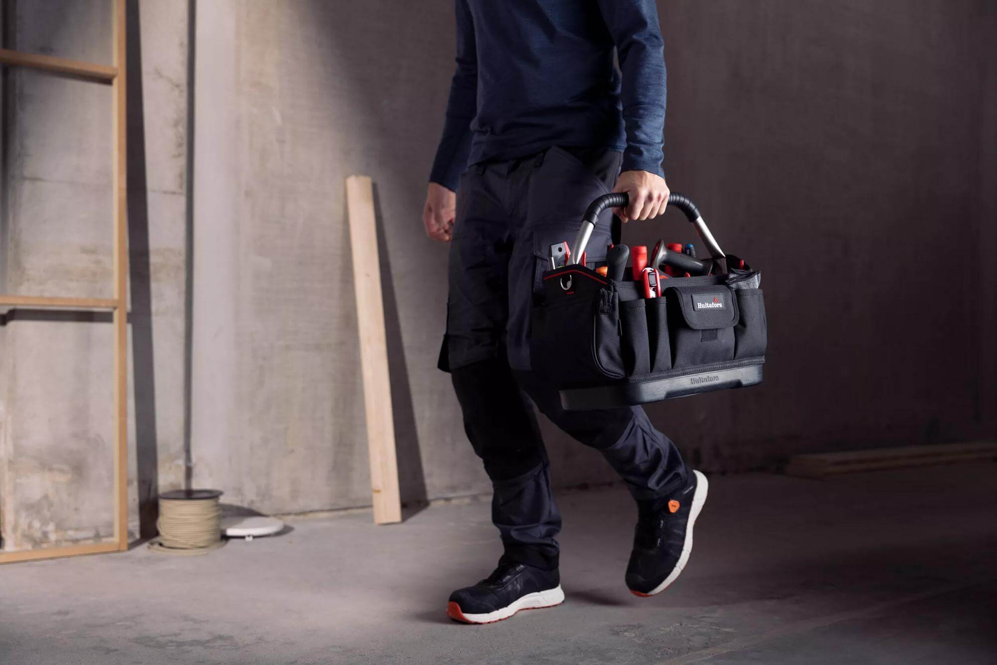 A technician carrying a durable tool bag at a repair site.