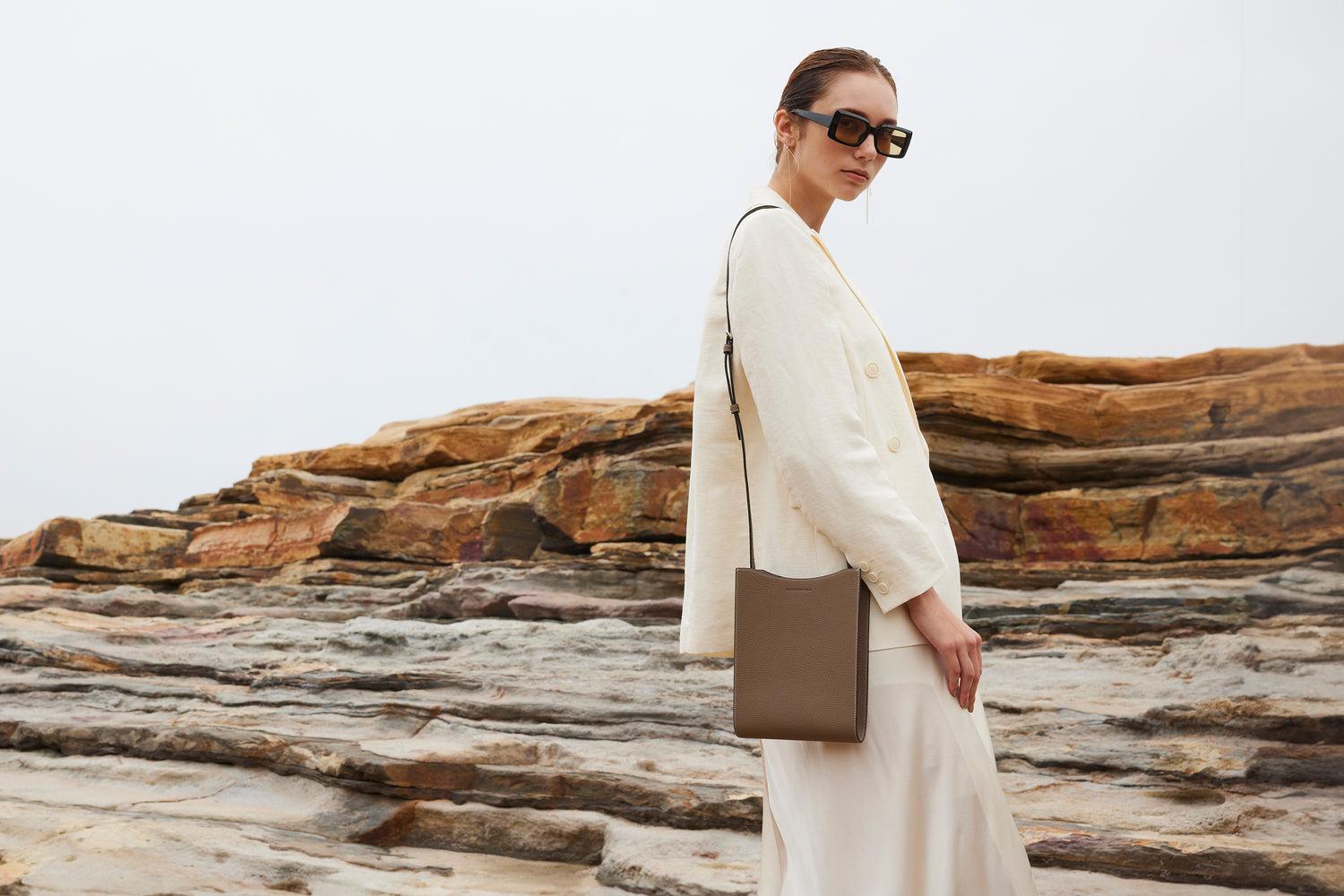 The exhibition showcased new designer bags against a neutral beige background, highlighting elegant silhouettes, textured leather, and exquisite hardware, all bathed in soft natural light.