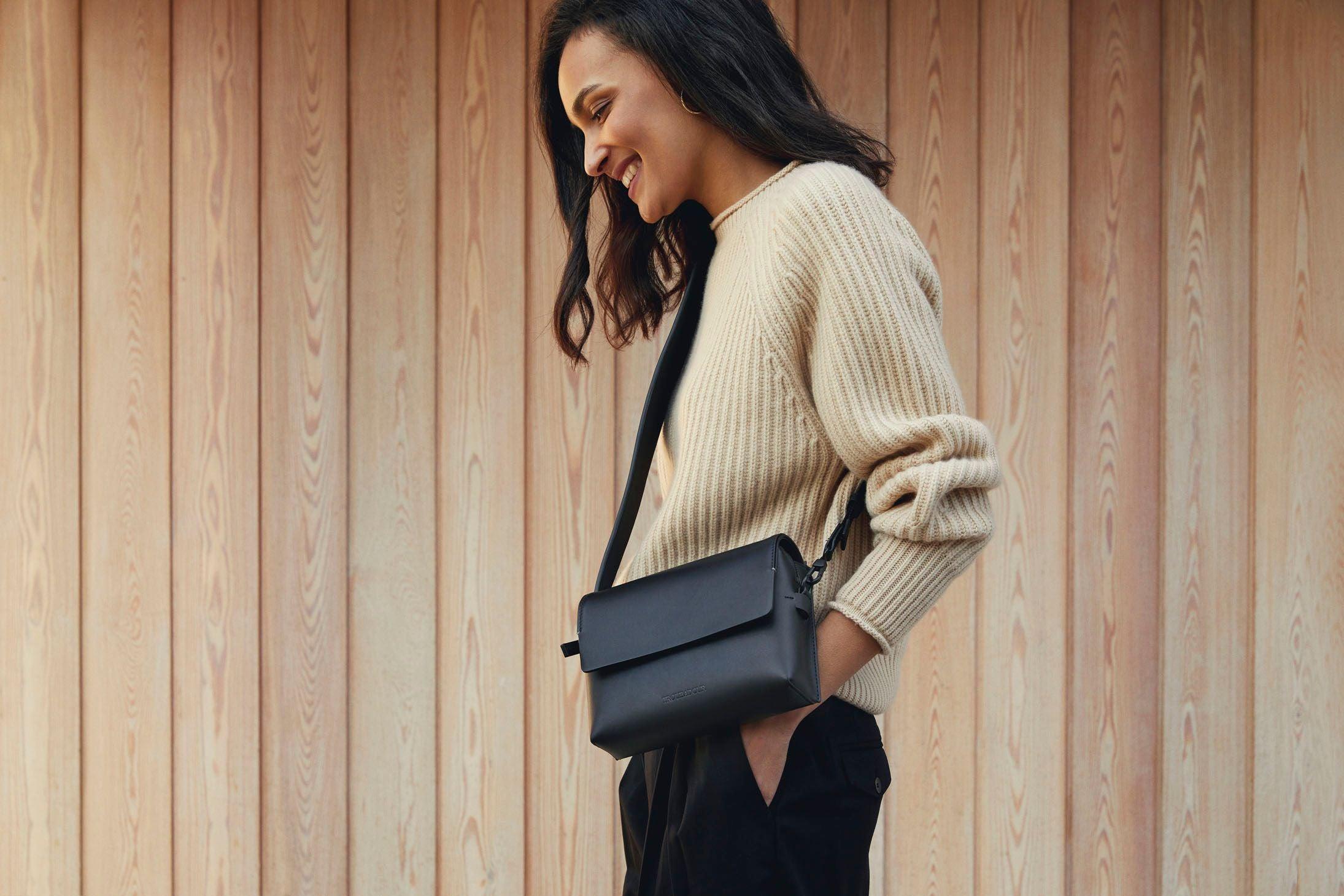 A stylish woman carrying new designer bags on a modern city street, showcasing everyday elegance and practical design