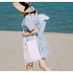 Woman folding blank plain cotton canvas beach swim shoulder sling bag