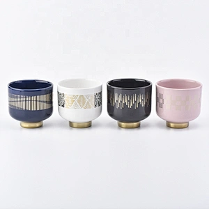 white ceramic candle jars with gold designs