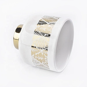 white ceramic candle jars with gold designs