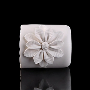 white ceramic candle vessel with flower