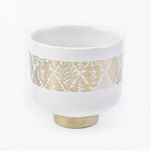 white ceramic candle jars with gold designs