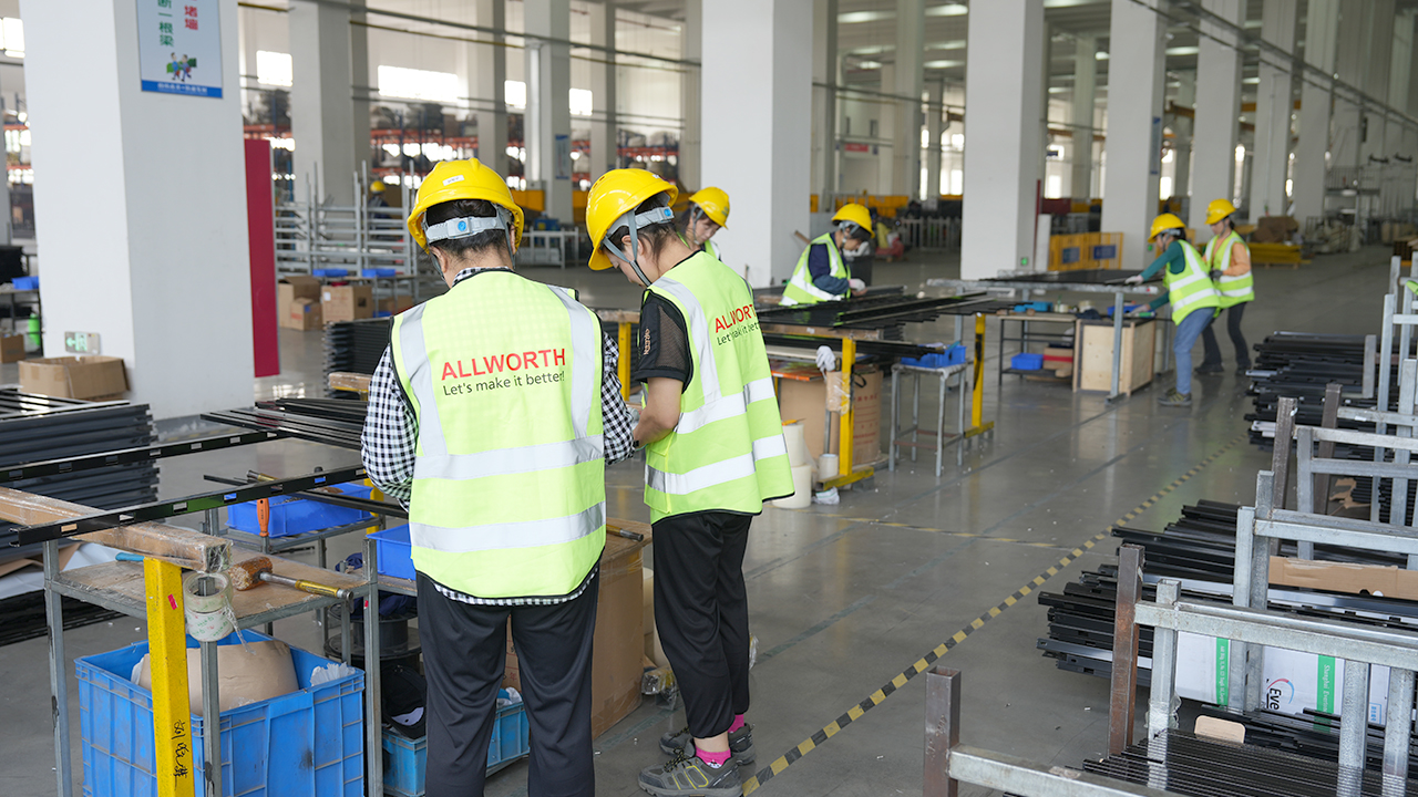 ALLWORTH team members handling metal components at a workbench