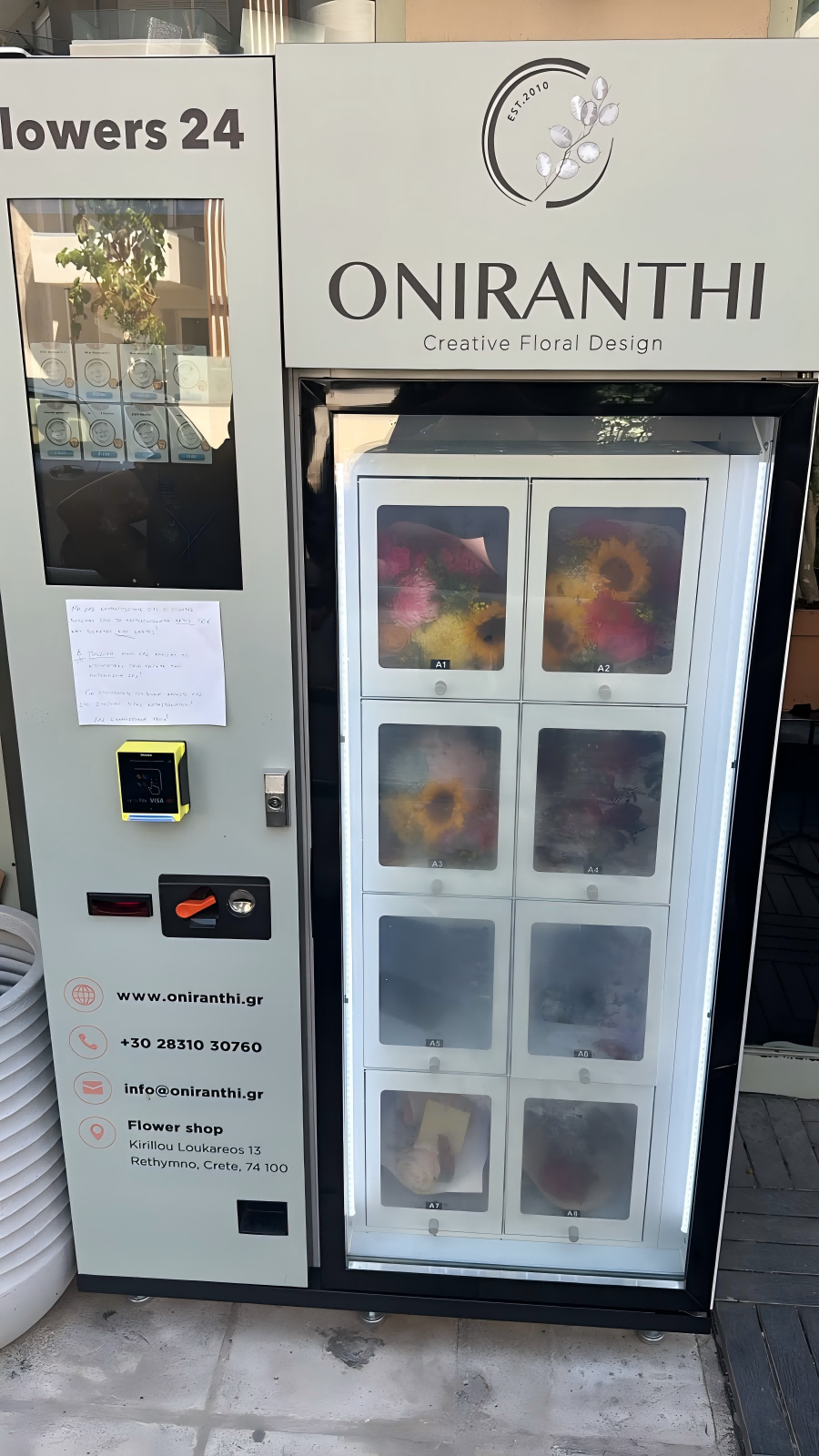 Temperature-controlled locker flower vending machine displaying fresh floral bouquets and gift boxes in a Greek shopping mall