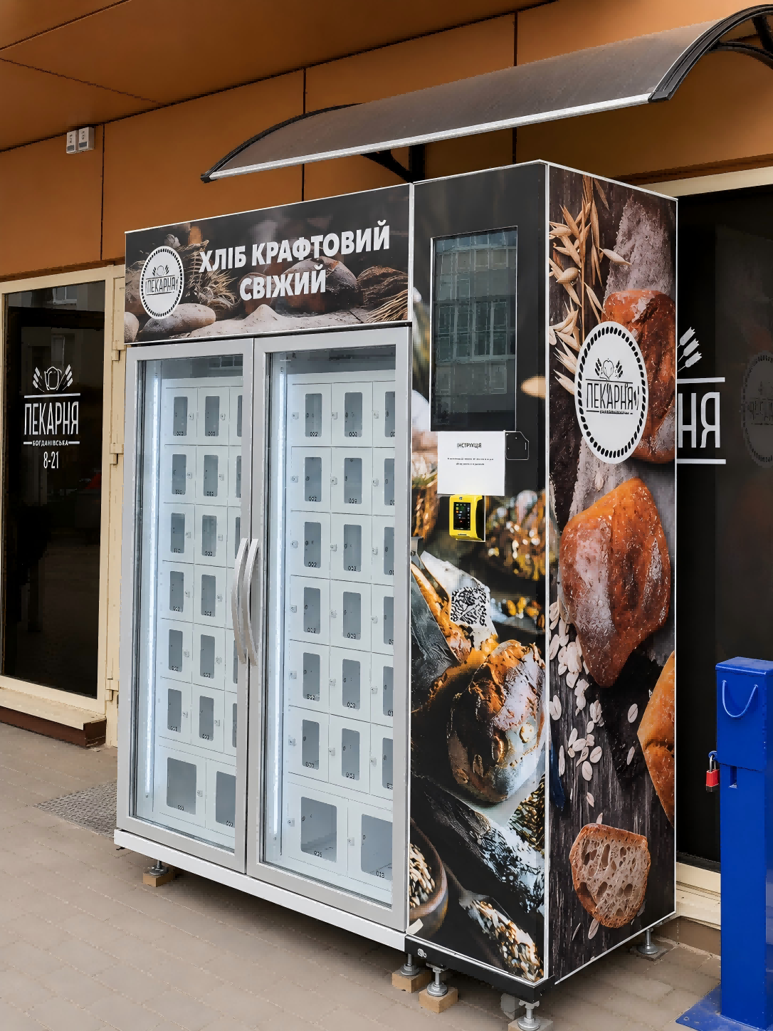 Outdoor temperature-controlled locker bread vending machine dispensing fresh sourdough loaves outside a Ukrainian bakery.