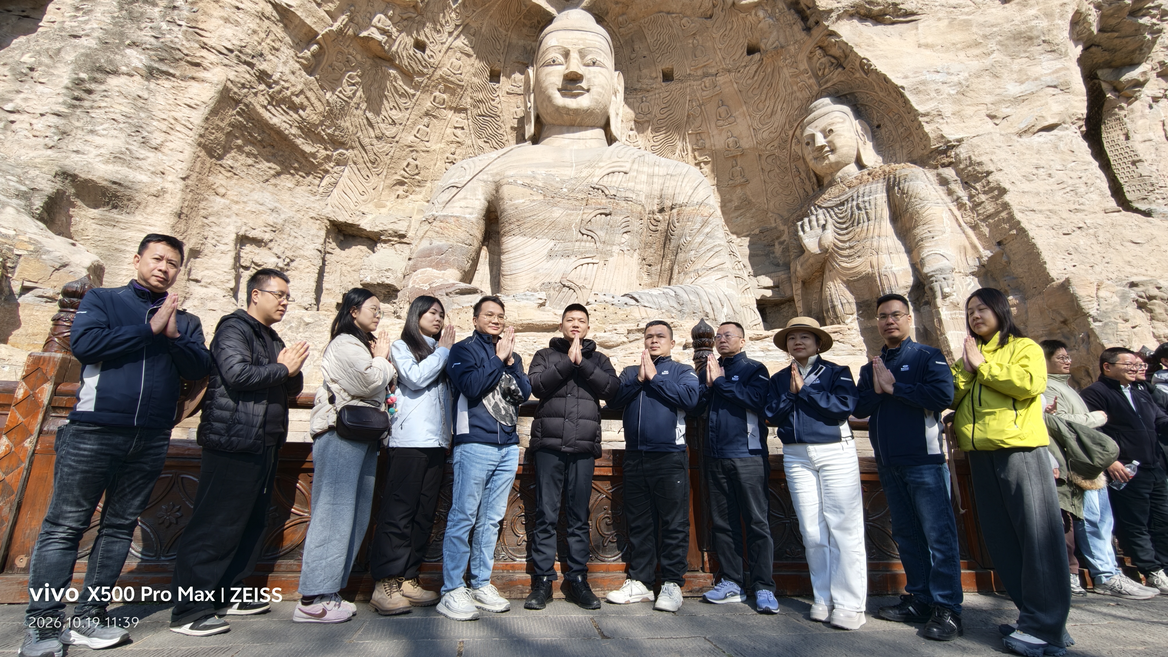 CHICO FUTURE team members posing for a group photo in front of the ancient Buddha sculptures at the Yungang Grottoes in Datong, China.