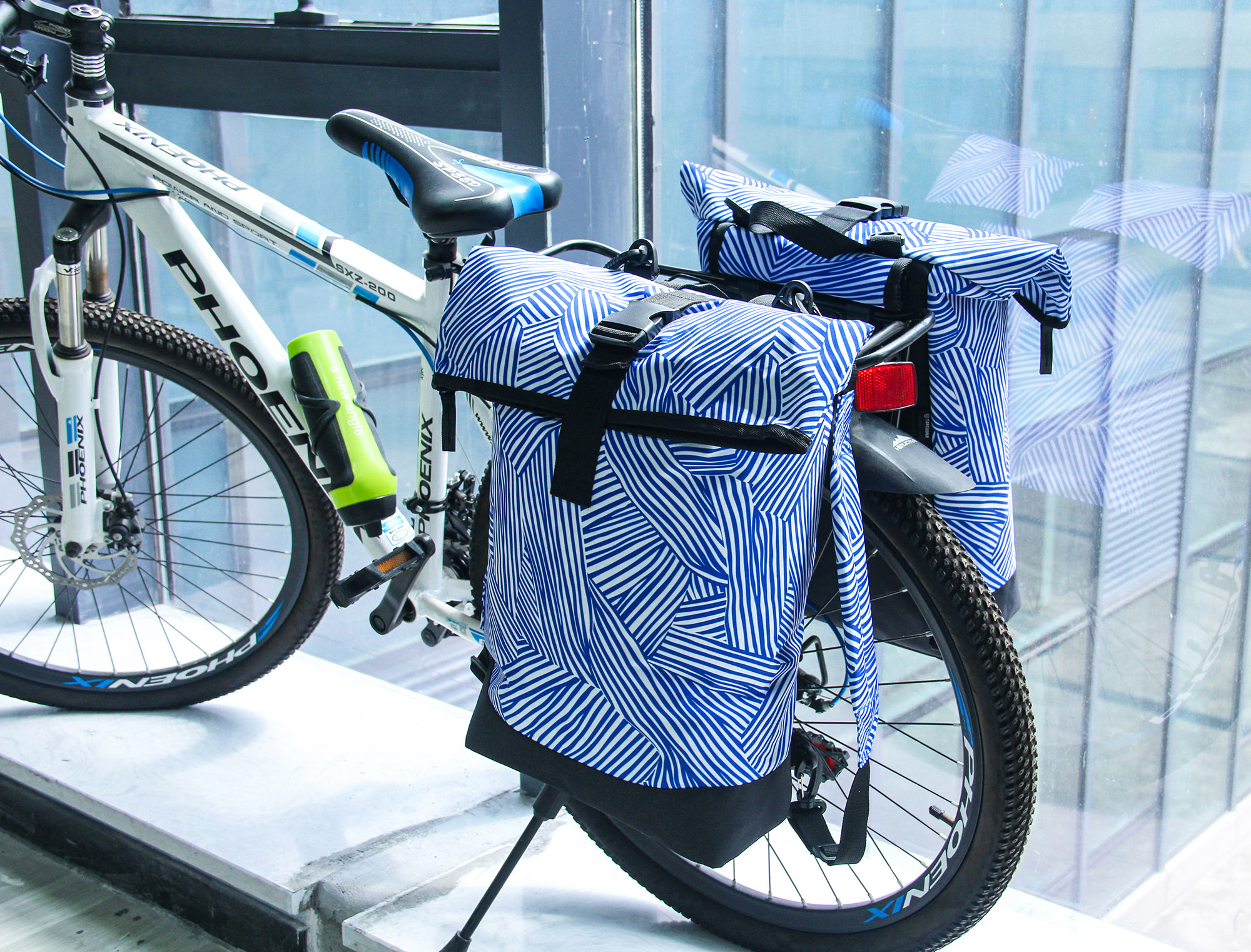 :Bicycle equipped with blue patterned 600D polyester panniers, durable bike rear bags for outdoor adventures