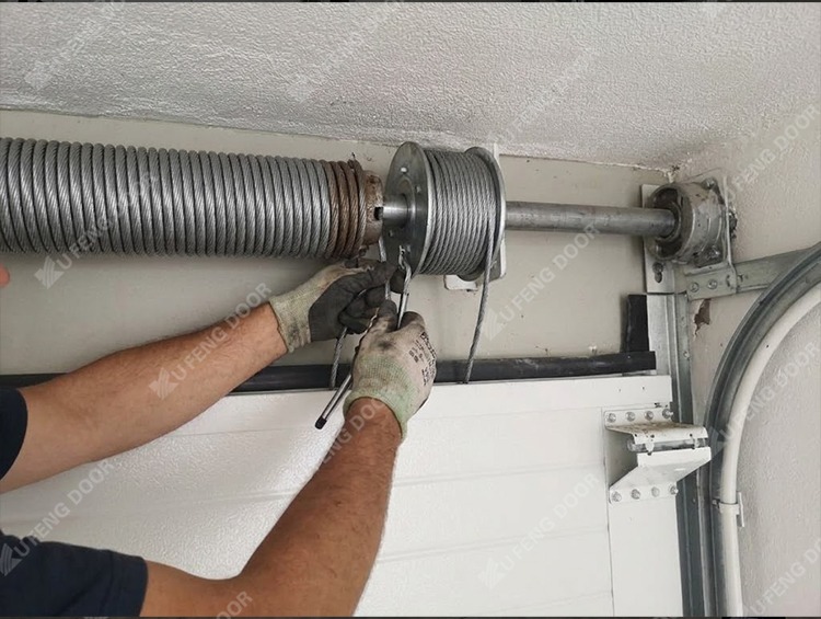Garage door spring and cable inspection checking torsion spring tension and steel lift cable wear