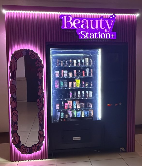 WEIMI WM22 beauty vending machine displaying cosmetics beneath Beauty Station+ signage beside a decorative mirror in El Salvador