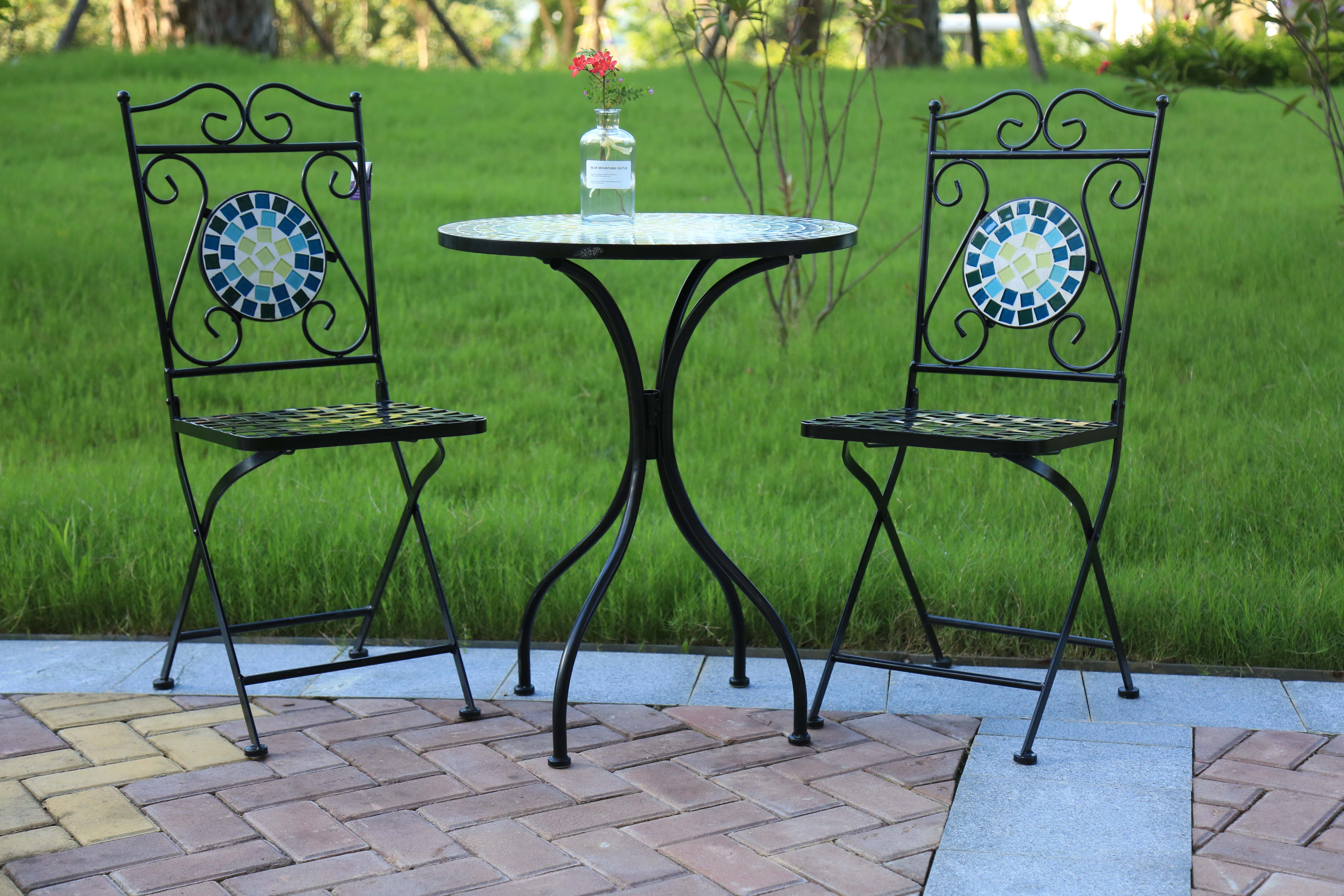 Mosaic outdoor tables with pair of chairs at park