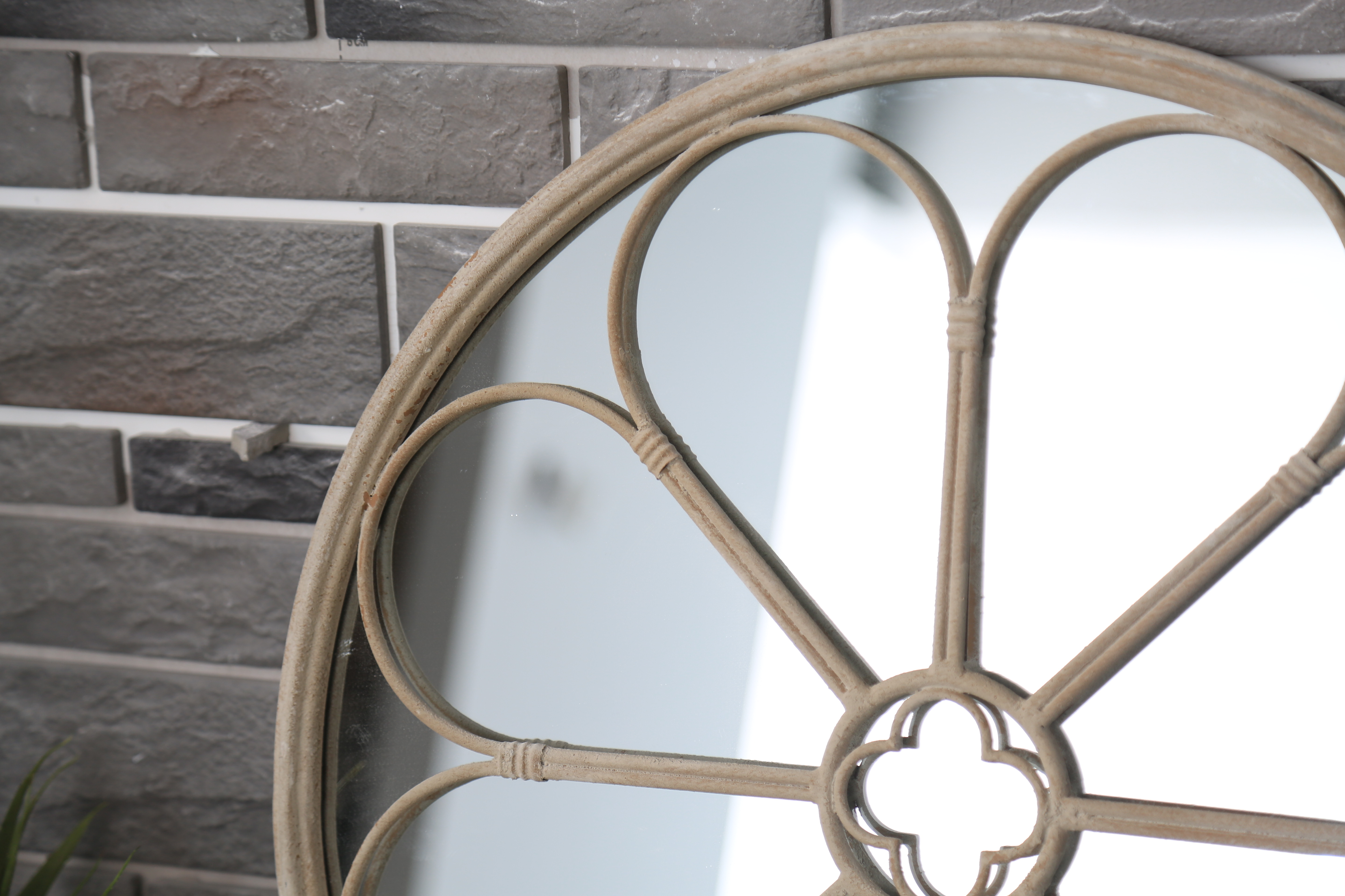 Close up view on round rattan mirror against the wall