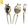 A divot tool is a small handheld device used to repair divots or marks on the golf course caused by golf balls landing on the ground.