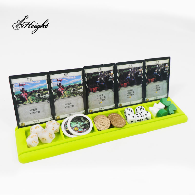 Green card stand with cards and some board game accessories