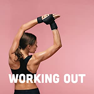 White woman in black workout clothes stretching her arms over her head