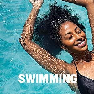 Black woman in a black bathing suit swimming with her eyes closed