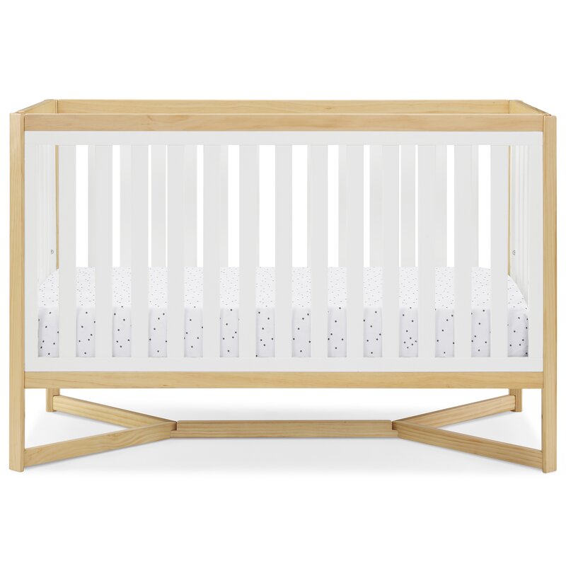 Light wood baby crib with guardrail