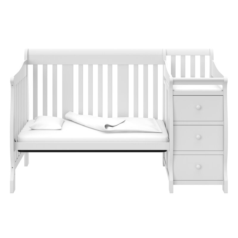 Light wood baby crib with guardrail and mattress