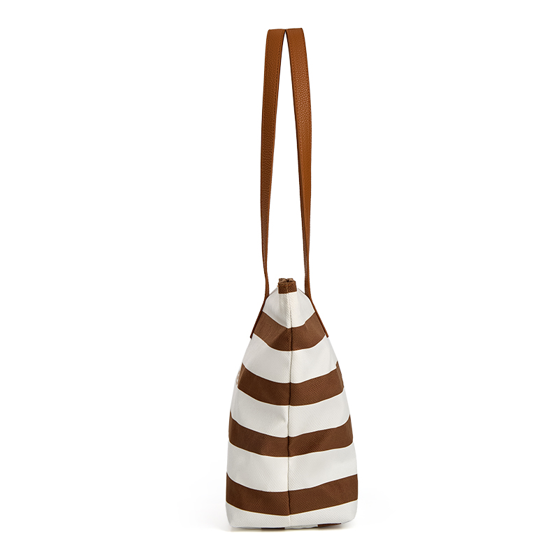 The side view of a brown tote bag, structured shape and long brown handles.