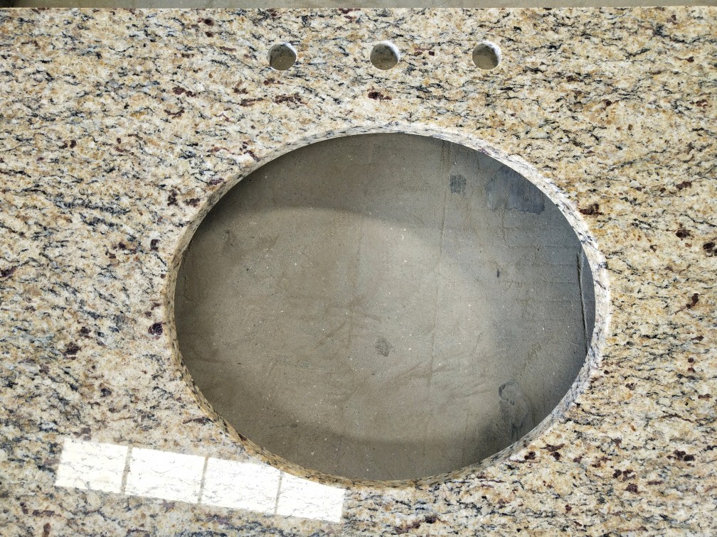 Ouro Brasil Granite Vanity Countertop uses a light honey-colored base with white, black and amber spots on the whole.