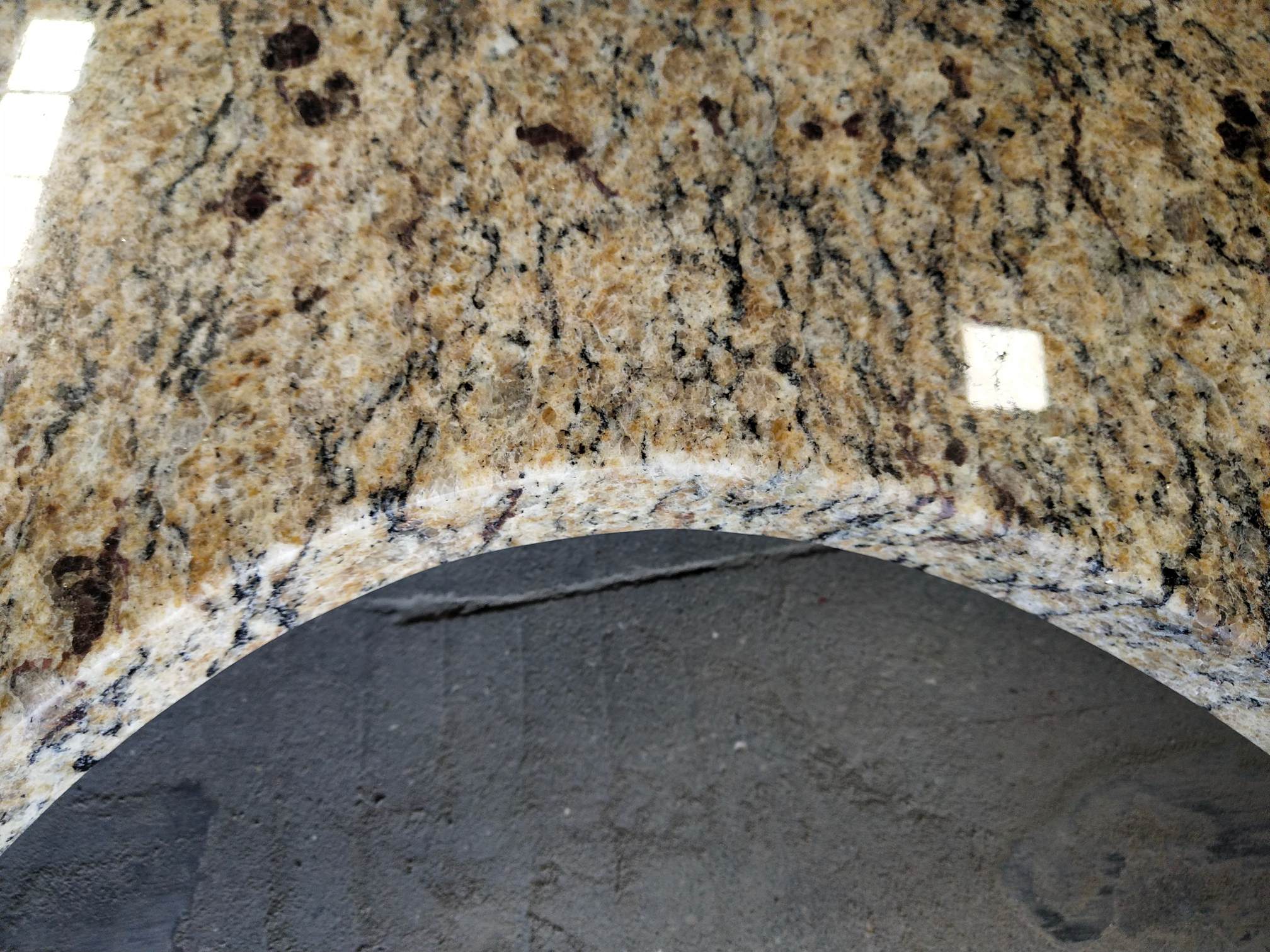 Ouro Brasil Granite Vanity Countertop uses a light honey-colored base with white, black and amber spots on the whole.