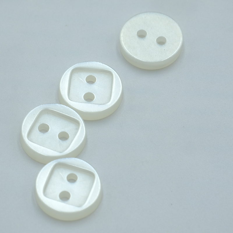 Resin buttons, versatile and durable fasteners, are crafted from synthetic resins and come in a wide array of colors, shapes, and styles.