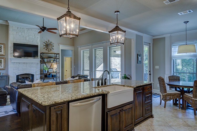 Modern grey kitchen with a pull-down kitchen faucet over a stone countertop