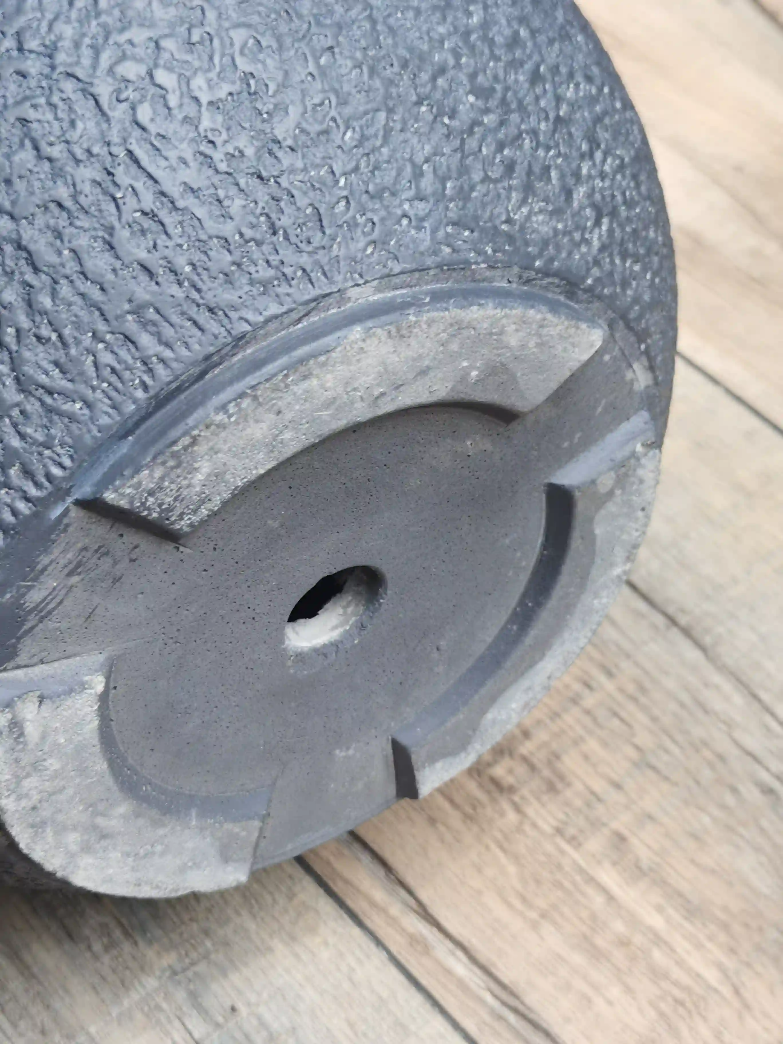 Close-up of a planter base showing a recessed drainage opening and raised support feet