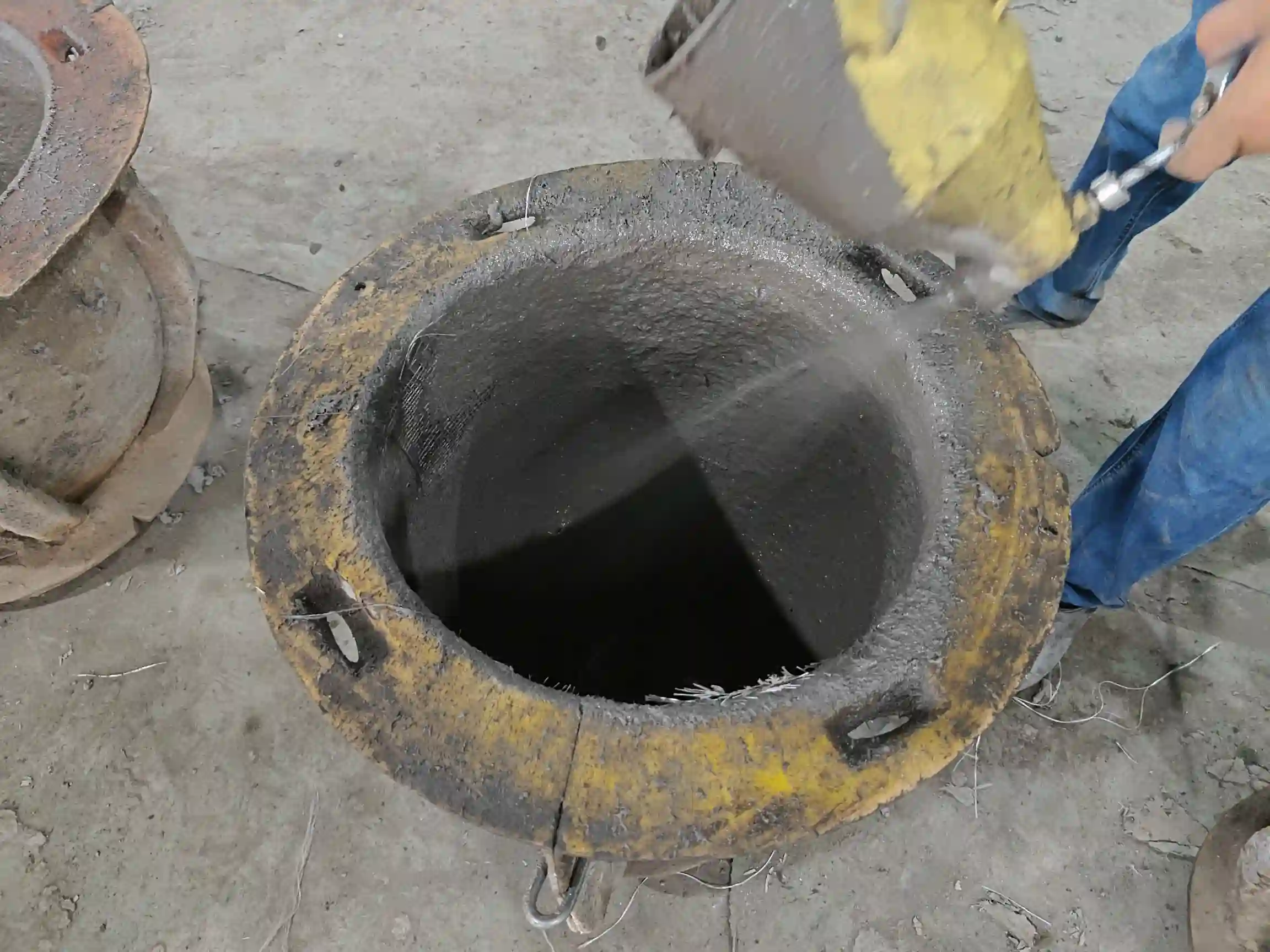 Worker applying wet composite material inside a planter mold at the Ronglin factory