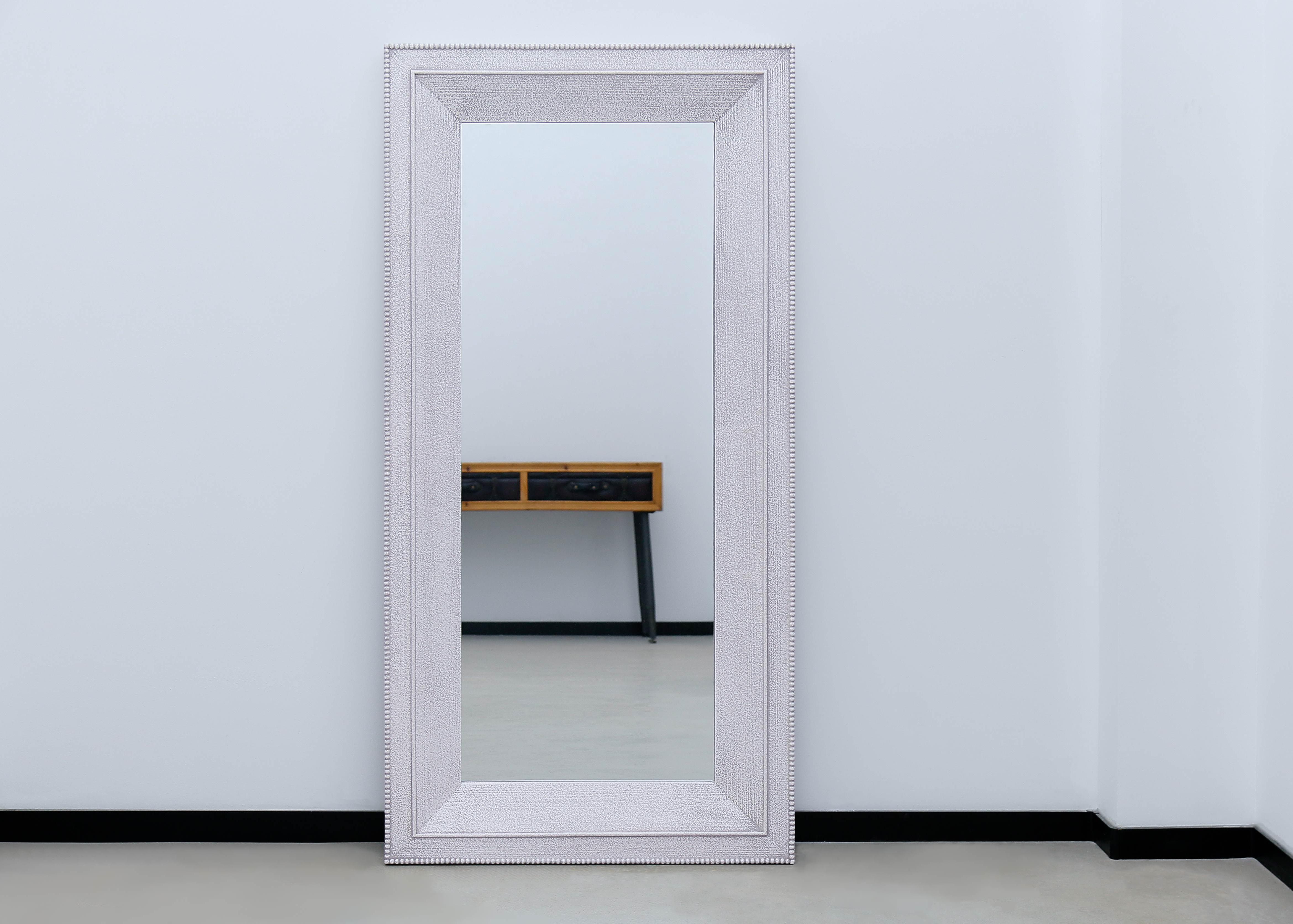 biggest floor mirror against white wall reflecting a table