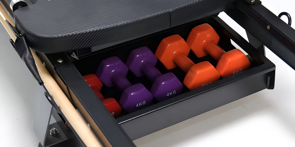 Pilates reformer with integrated dumbbell rack
