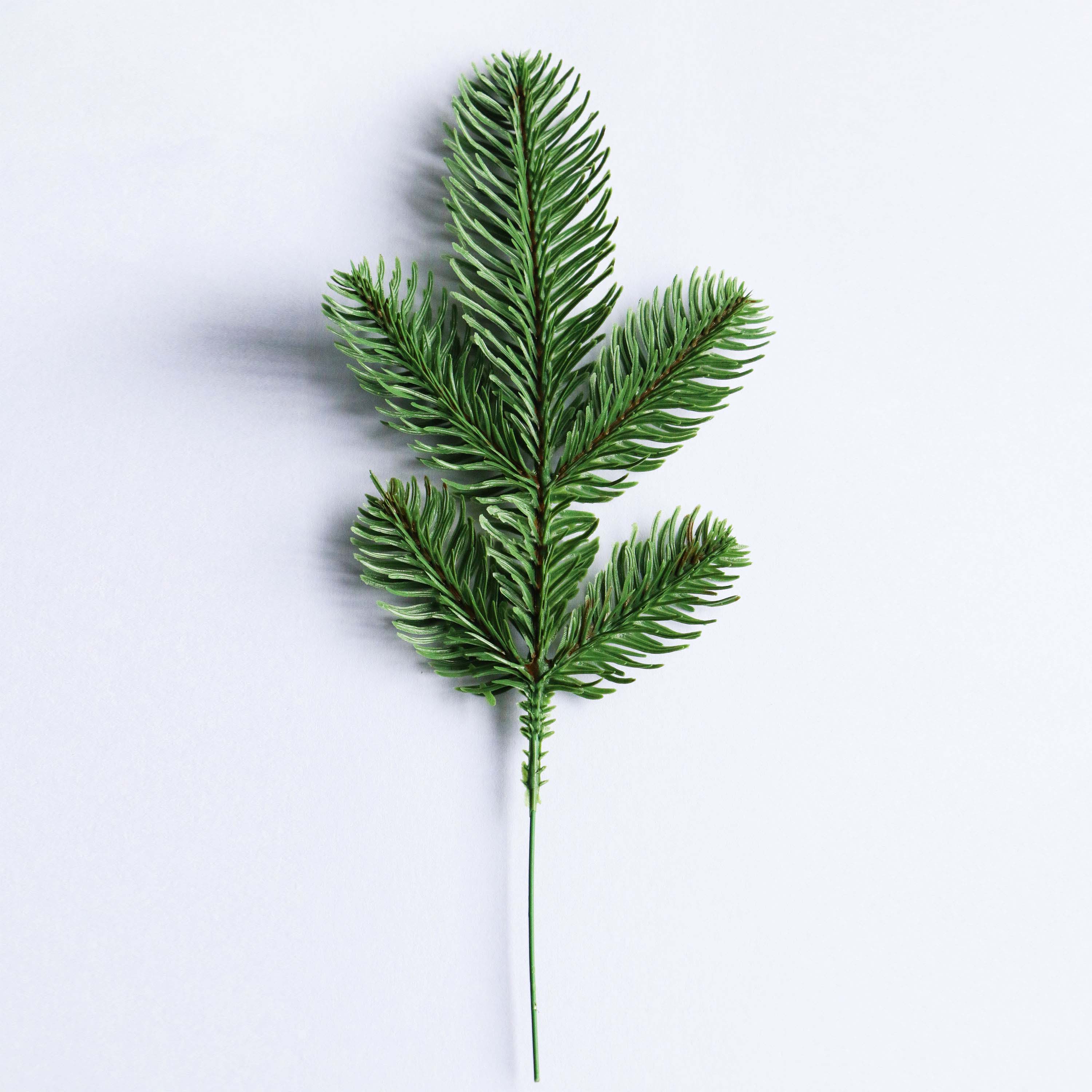 Artificial pine branch Christmas decor lifelike faux pine sprig for wreaths centerpieces and holiday arrangements durable maintenance-free festive greenery.